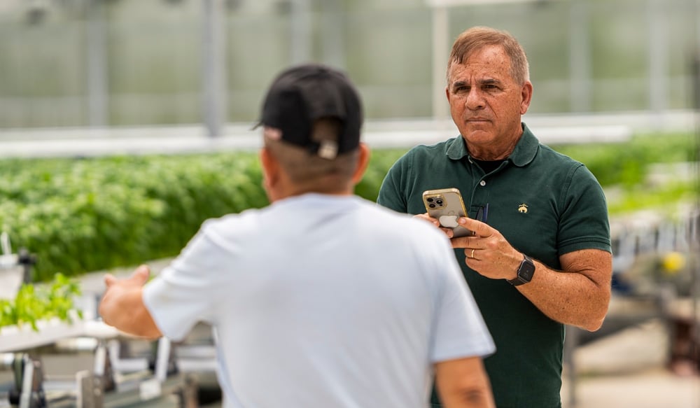 Brian Murphy, founder and President of Goodness Gardens, discusses production with a colleague. For him, the value of automation goes beyond labour savings to include capacity, production flow and better use of employees’ skills.